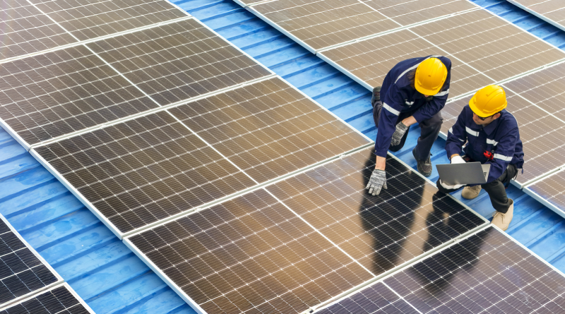 Two engineers inspecting rooftop solar panels showcasing the advantages of solar energy.