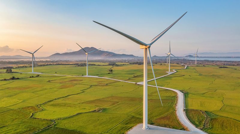 Large offshore wind turbines generating renewable energy at sunrise