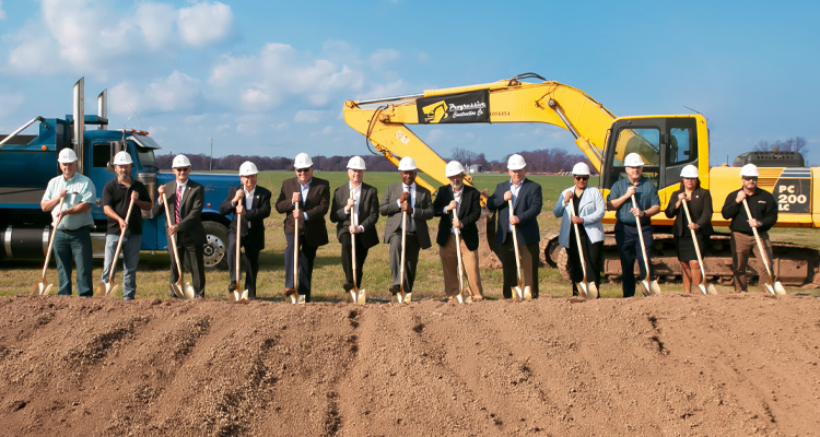 a group of 13 people participating in a groundbreaking ceremony