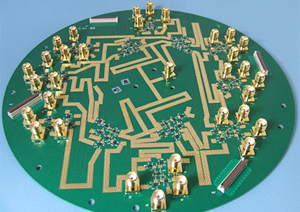 a round, green printed circuit board with gold-coloured traces and numerous edge-mounted radio-frequency coaxial connectors