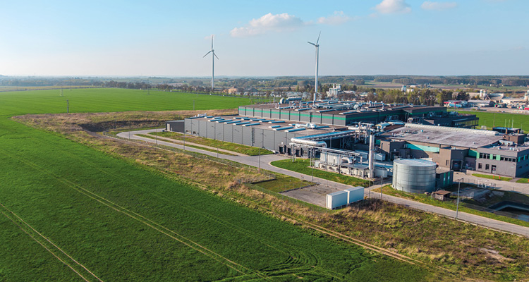 a data center complex set in a rural landscape with nearby wind turbines
