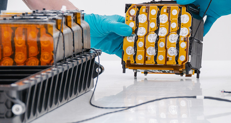 a technician handling a module from the RML Group VarEVolt electric vehicle battery pack